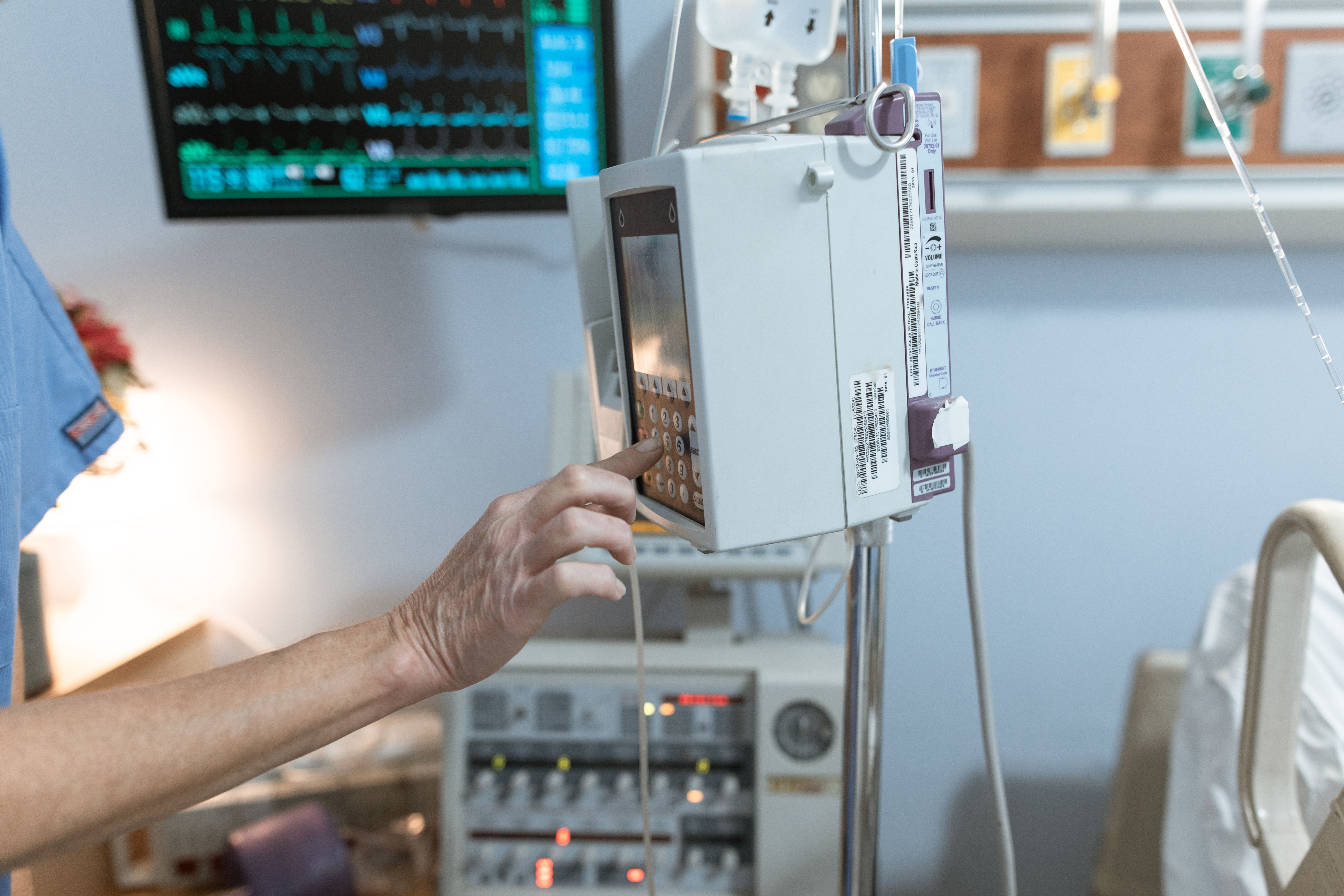 Healthcare professional operating an infusion pump in a hospital